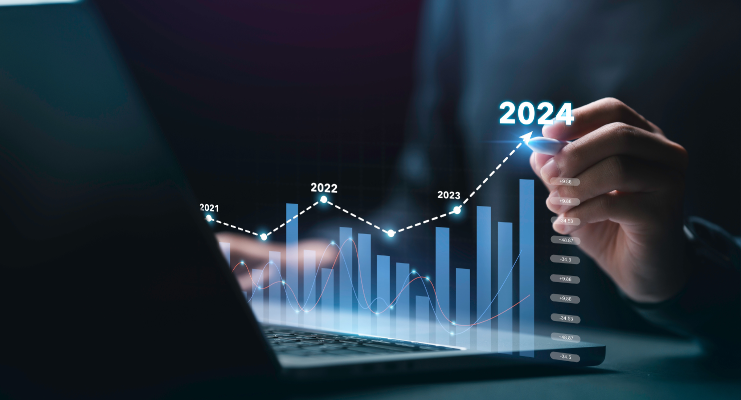 Person analyzing a forecast graph on a laptop showing rising stock trends up to the year 2024, indicating market growth.